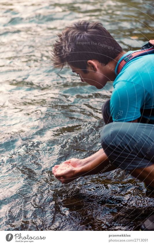 Kleiner Junge, der reines Wasser aus einem Fluss in den Händen nimmt. Körper Leben Mensch Mann Erwachsene Hand Umwelt Natur See Tropfen frisch nass natürlich