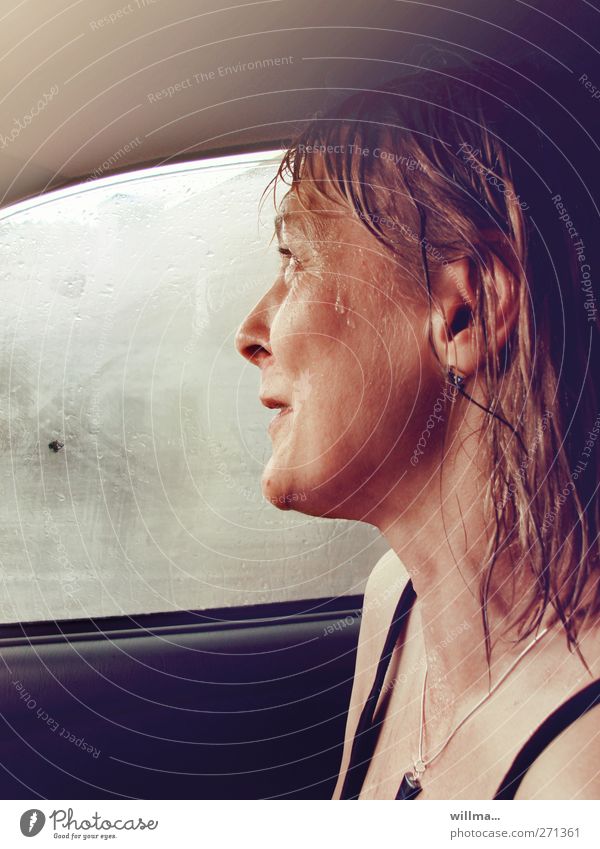 Frau sitzt im Auto, nass vom Regen, und lacht regennass Regenwetter Fröhlichkeit Autofenster Lächeln lachen erleben Lebensfreude Freude natürlich authentisch