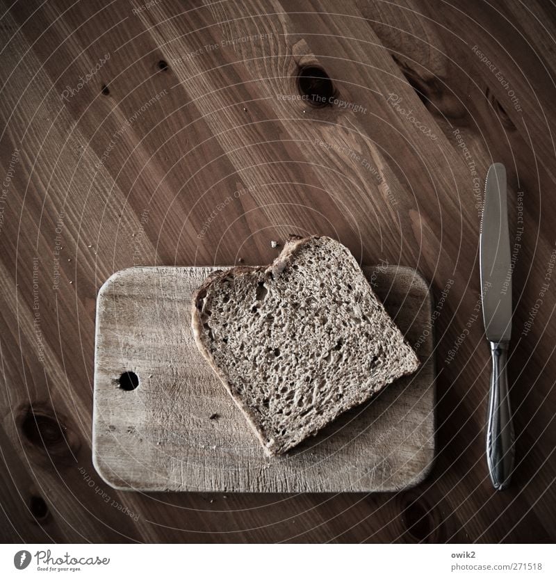 Kalte Küche Lebensmittel Brot Brotscheibe Schnitte Schnittbrot Ernährung Frühstück Diät Messer Schneidebrett Tischplatte Holz Holzbrett Holztisch Metall liegen