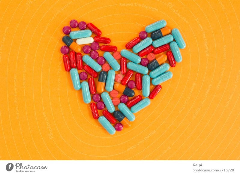 Herzförmig angeordnete Pillen auf orangem Hintergrund Flasche Gesundheitswesen Behandlung Krankheit Medikament Wissenschaften Krankenhaus blau weiß Schmerz