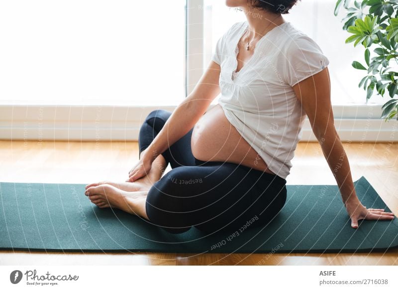 Schwangere Frau beim Training auf einer Matte zu Hause Glück Körper Erholung Sport Yoga Baby Erwachsene Eltern Mutter Fitness schwanger grün Zukunft