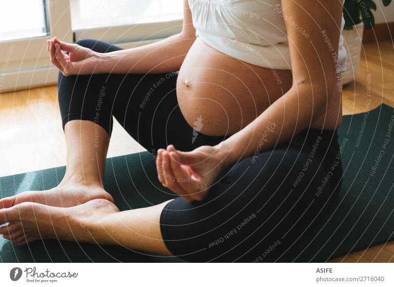 Schwangere Frau beim Yoga zu Hause Glück Körper Erholung Sport Baby Erwachsene Eltern Mutter Fitness schwanger grün Zukunft Schwangerschaft üben Lotos