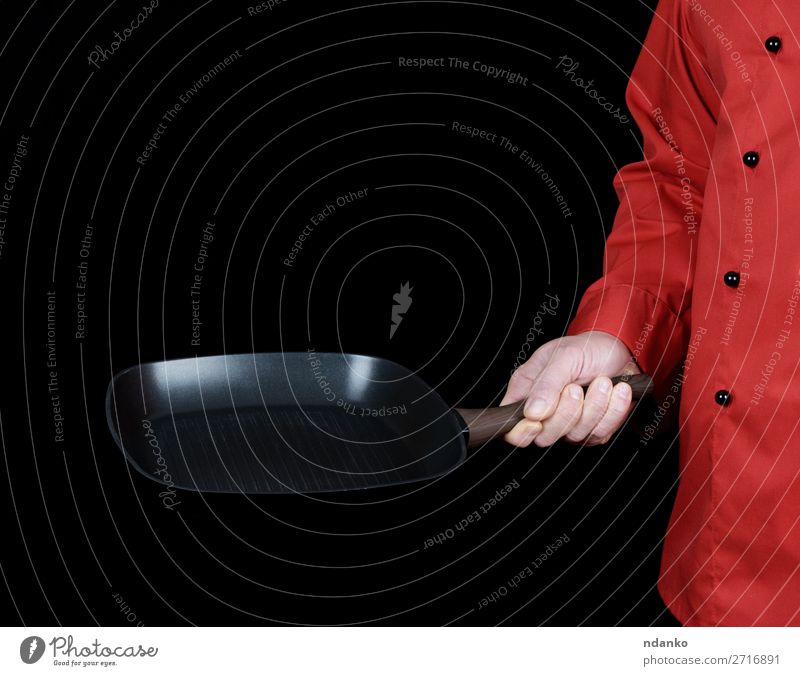 in roter Uniform kochen und eine Bratpfanne halten Pfanne Küche Restaurant Koch Mensch Mann Erwachsene Hand Bekleidung schwarz Gußeisen Kaukasier Küchenchef