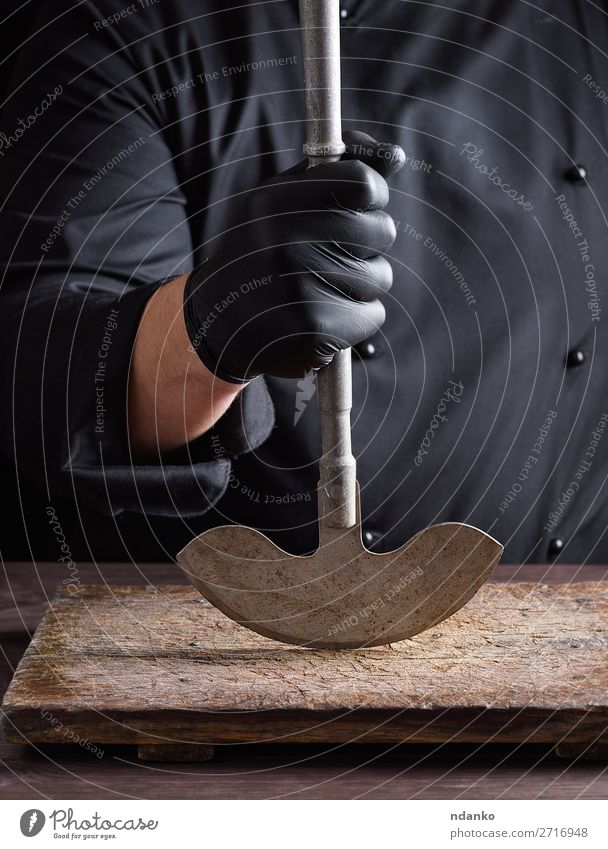 Chefkoch in schwarzer Kleidung hält Metall altes Messer fest Küche Arbeit & Erwerbstätigkeit Koch Mann Erwachsene Hand Handschuhe Stahl machen groß Klinge