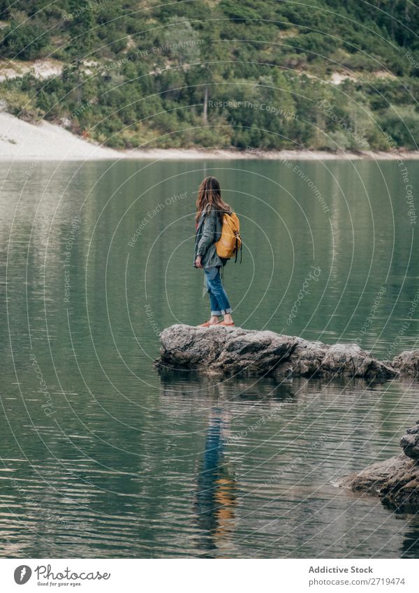 Backpackerin auf Stein im See Frau Rucksack Berge u. Gebirge Tourismus Landschaft Aktion Freiheit Tourist Abenteuer Natur Körperhaltung Wasser Rippeln