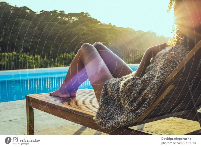 Frau, die sich auf einer Hängematte entspannt und den Sonnenuntergang am Schwimmbad genießt. schön Buch Stuhl bequem Landschaft Tag Schiffsdeck genießend Genuss