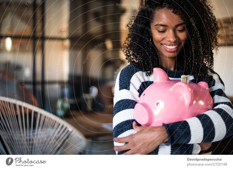 Schwarze Frau umarmt ihr Sparschwein. Spardose Einsparungen Erfolg Business Bargeld schwarz Geld Geldmünzen US-Dollar schön Glück heiter Investition Vermögen