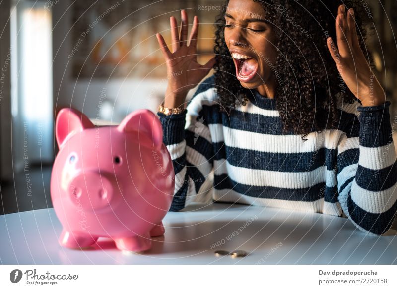 Schwarze unglückliche Frau wütend auf das Sparschwein Spardose Einsparungen Krise Traurigkeit Wut Stress Gefühle verärgert schreien Ärger Ausdruck frustriert