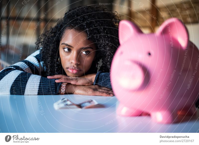 Traurig frustrierte schwarze Frau mit Sparschwein Spardose Schulden Krise Traurigkeit Haushaltsplan Wut beunruhigt Kapitalwirtschaft verärgert Stress Fürsorge