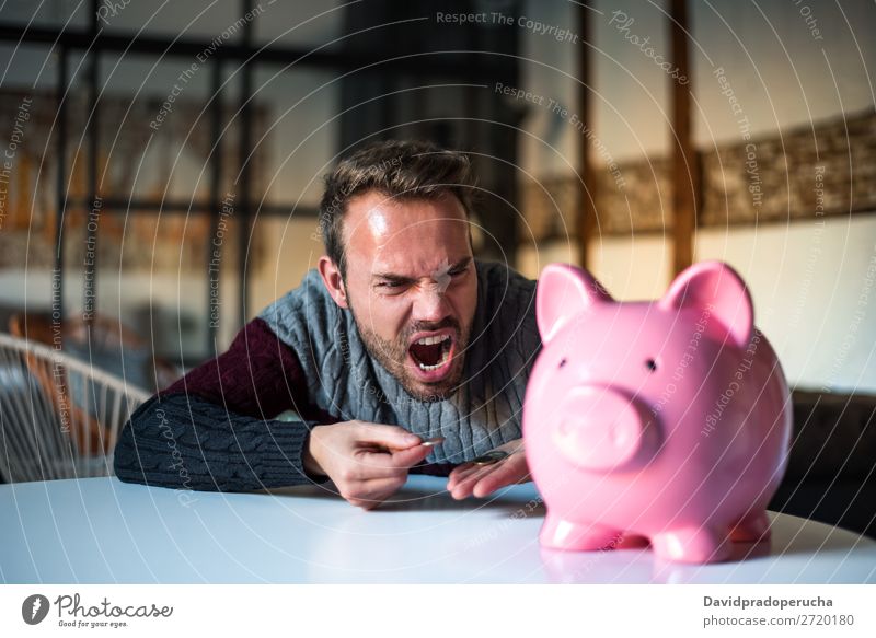 Unglücklicher Mann wütend auf sein Sparschwein Spardose Einsparungen Krise Traurigkeit Wut Stress Gefühle verärgert schreien Ärger Ausdruck frustriert