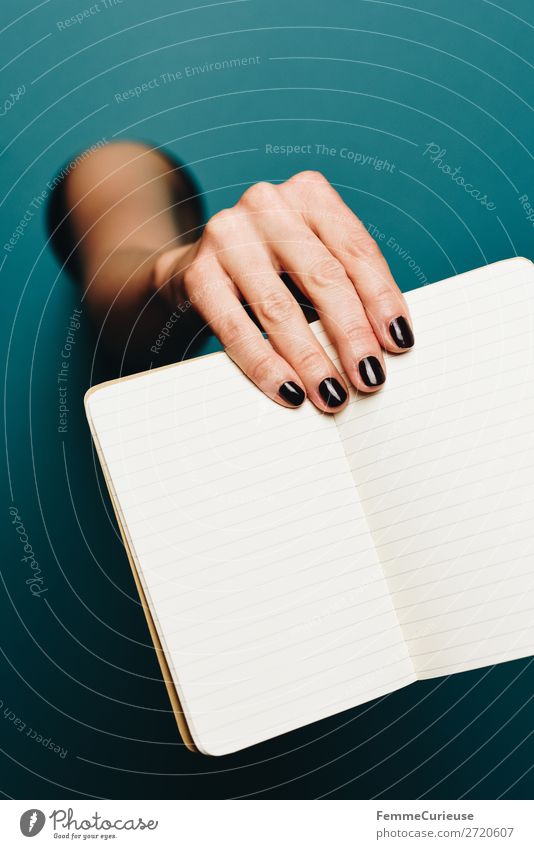 A woman's hand holding an empty notebook feminin 1 Mensch Schreibwaren Papier Zettel Kommunizieren Notizbuch schreiben leer Nagellack schwarz türkis Unterarm