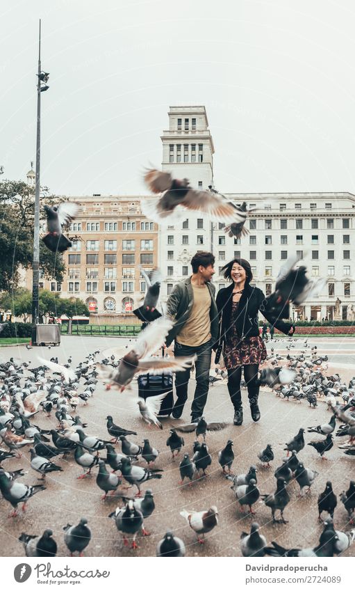 Asiatisches glückliches Touristenpaar, das mit dem Koffer läuft. Paar asiatisch Spanien Freude Freundschaft Tourismus Barcelona Ferien & Urlaub & Reisen