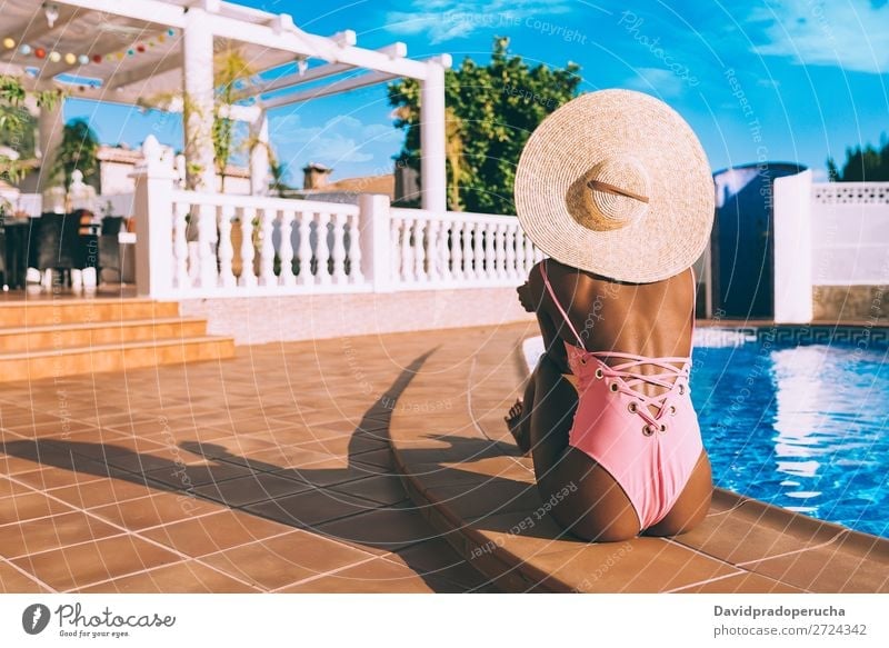 Schwarze Frau sitzt in einem Swimmingpool. schwarz urwüchsig Schwimmbad Sommer Sonnenbad Ferien & Urlaub & Reisen Bräune horizontal Bräunen Erholung