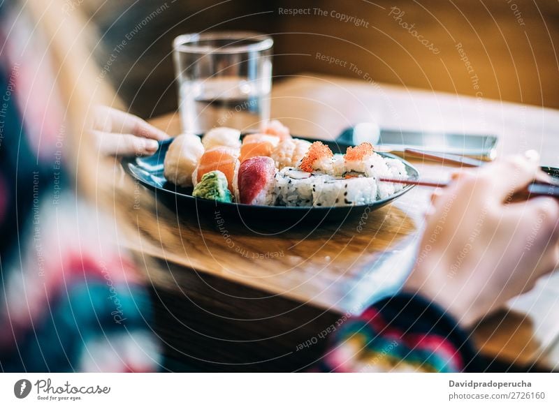 Getreidefrau beim Sushi essen Frau Hand Lebensmittel Soja maki Kalifornische Walze Essstäbchen Brötchen Feldfrüchte unkenntlich anonym Nahaufnahme Porträt Lachs