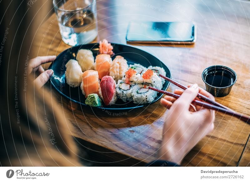 Getreidefrau beim Sushi essen Frau Vogelperspektive Hand Lebensmittel Soja maki Kalifornische Walze Essstäbchen Brötchen Feldfrüchte unkenntlich anonym