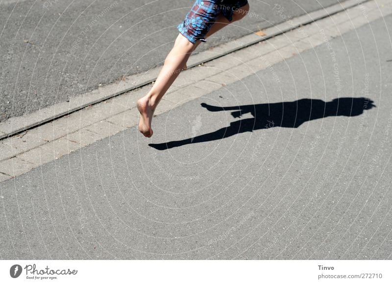 Beine von über Asphalt hüpfendem Jungen und Körperschatten Fuß 1 Mensch Sonnenlicht Sommer Schönes Wetter Verkehrswege Fußgänger Straße laufen rennen springen