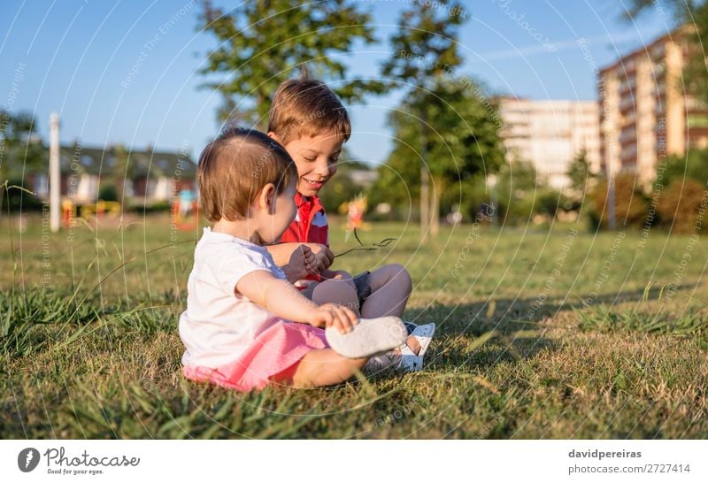 Kleinkind und Kind beim Spielen auf einem Rasenplatz sitzend Lifestyle Freude Glück schön Freizeit & Hobby Sommer Garten Mensch Baby Junge Schwester