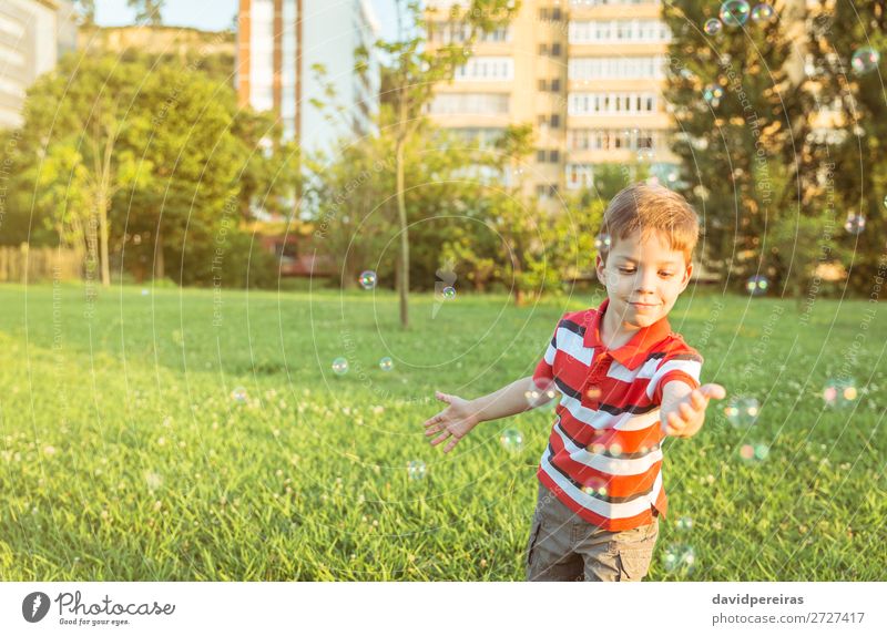 Glücklicher Junge spielt mit Seifenblasen im Park. Lifestyle Freude schön Leben Erholung Freizeit & Hobby Spielen Freiheit Sommer Garten Kind Mensch Mann