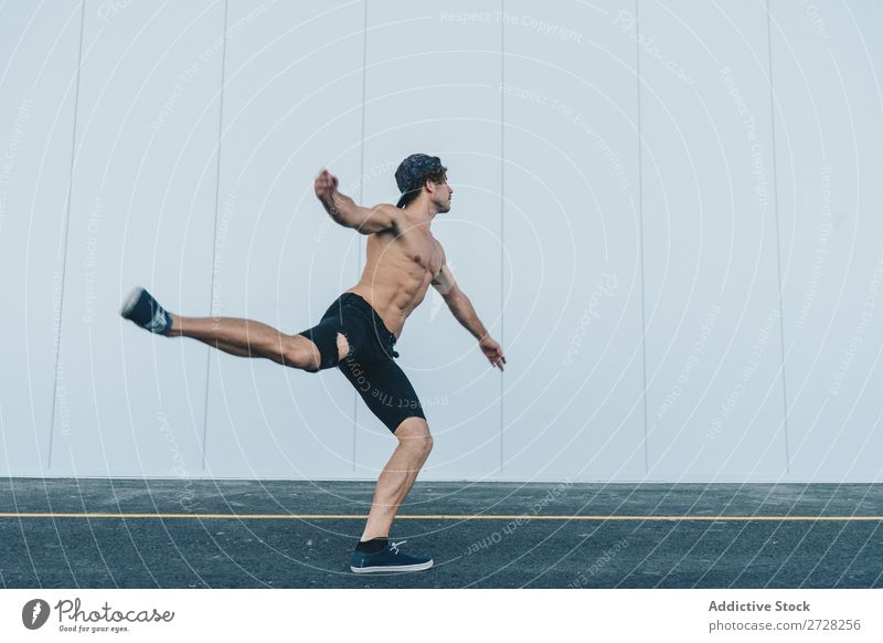 Sportlicher Mann tanzt auf der Straße Tänzer Körperhaltung Stadt Schickimicki elegant Tanzen sportlich Leistung Gleichgewicht muskulös Bein hoch Bewegung
