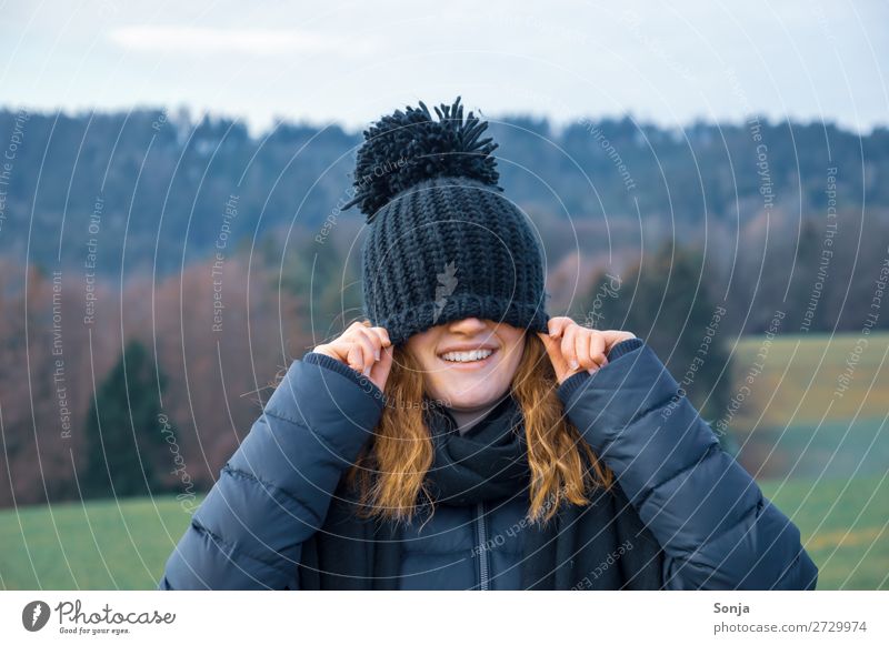 Jungesl ächendes Mädchen mit einer blauen Mütze über dem Gesicht Lifestyle Freude Glück Ausflug Winter wandern feminin Junge Frau Jugendliche 1 Mensch