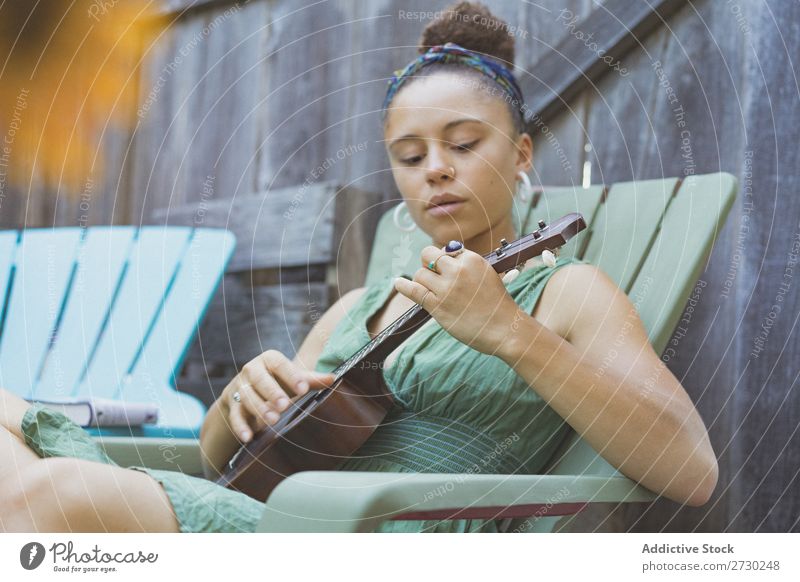 Mädchen spielt Ukulele im Gartenstuhl Frau Musiker Erholung Sommer Gitarre Instrument schön Jugendliche Künstler Lifestyle Freizeit & Hobby Musical Klang