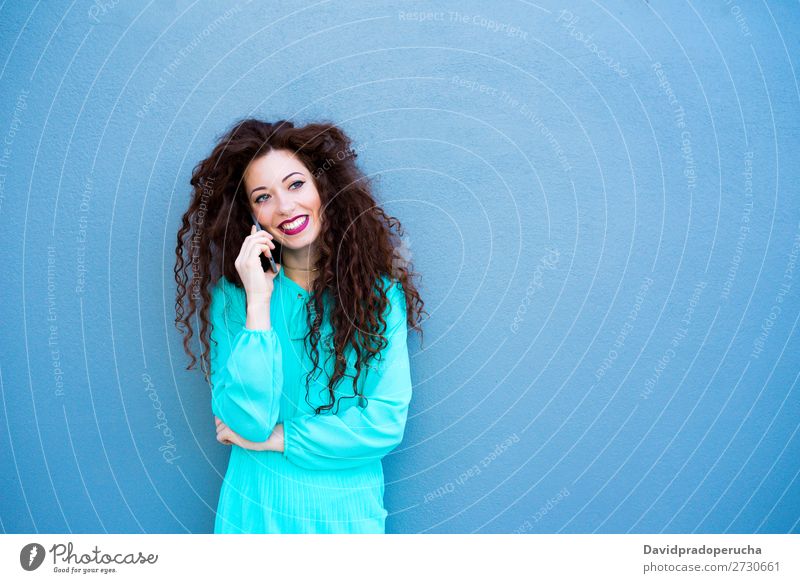 Glückliche junge Frau auf dem Handy an einer bunten Wand rothaarig Telefon Business Geschäftsfrau Technik & Technologie Mobile Lächeln Gesicht Beautyfotografie