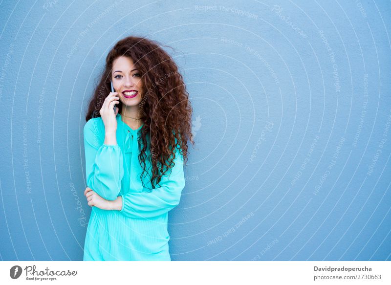 Glückliche junge Frau auf dem Handy an einer bunten Wand rothaarig Telefon Business Geschäftsfrau Technik & Technologie Mobile Lächeln Gesicht Beautyfotografie