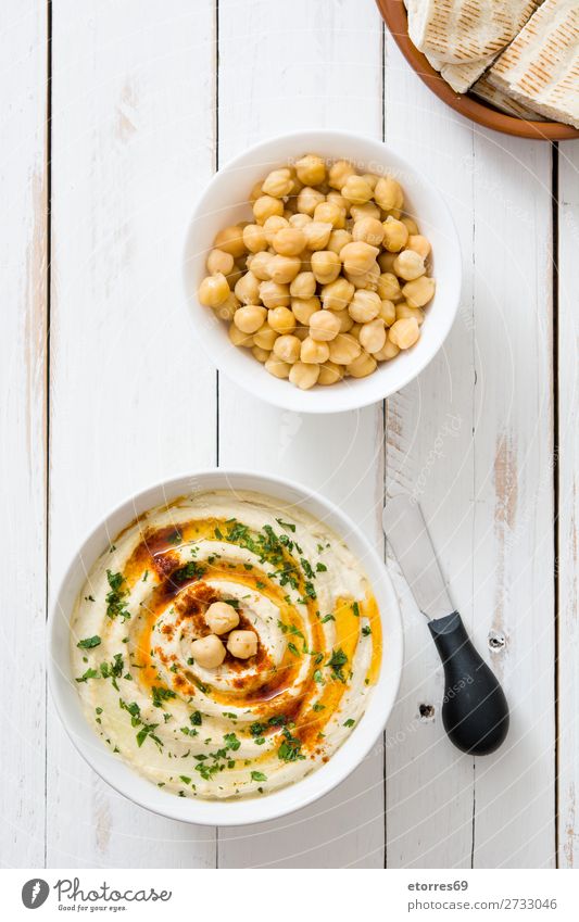 Hummus in der Schüssel und Pita-Brot auf Holztisch. Lebensmittel Gesunde Ernährung Foodfotografie Speise Kichererbsen Koriander Zitrone Olivenöl