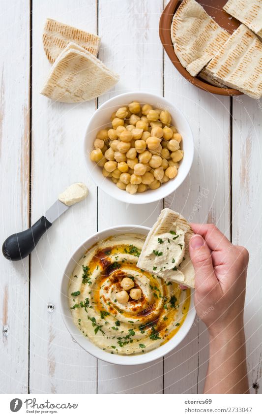 Hummus in der Schüssel und Pita-Brot auf Holztisch. Lebensmittel Gesunde Ernährung Foodfotografie Speise Kichererbsen Koriander Zitrone Olivenöl