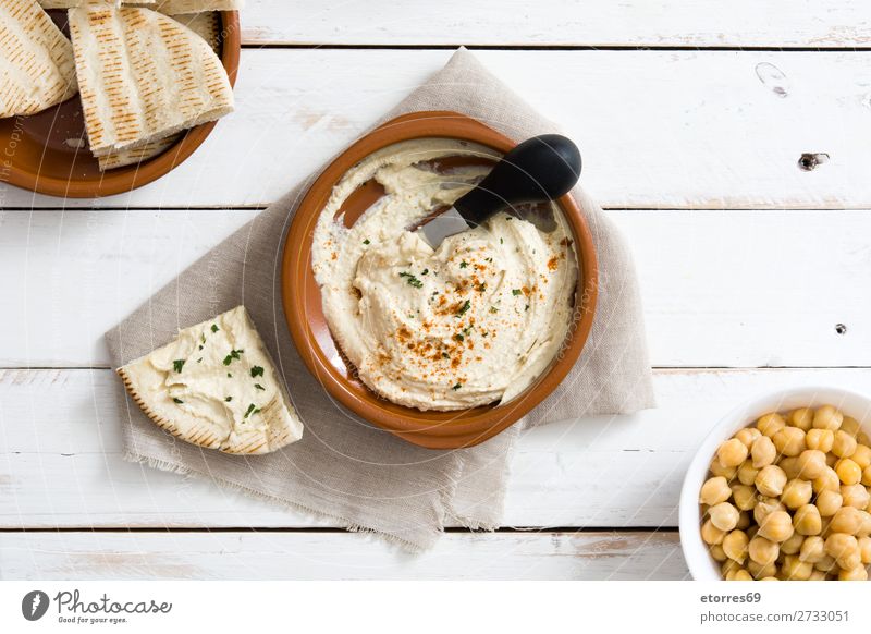 Hummus in der Schüssel und Pita-Brot auf weißem Holztisch. Lebensmittel Gesunde Ernährung Foodfotografie Kichererbsen Koriander Zitrone Olivenöl