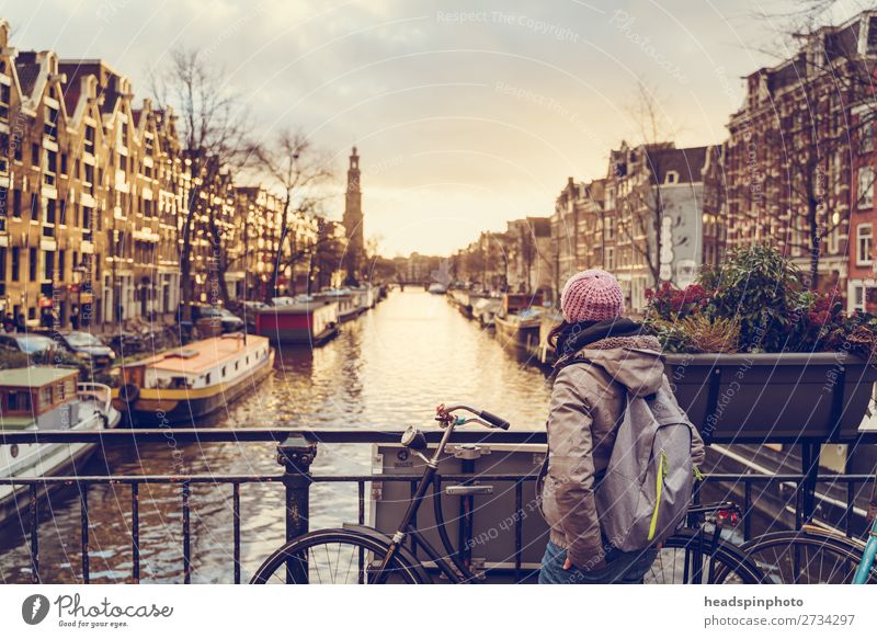 Frau guckt bei Sonnenuntergang auf einen der Kanäle im Amsterdam Ferien & Urlaub & Reisen Tourismus Ausflug Sightseeing Städtereise feminin Junge Frau