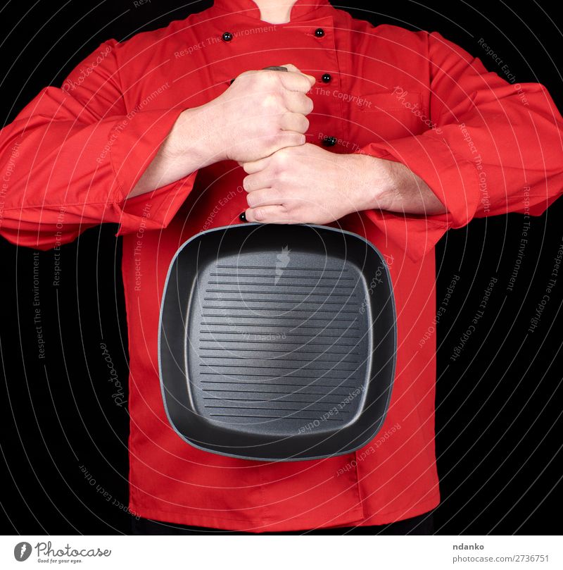 in roter Uniform kochen und eine leere quadratische schwarze Bratpfanne halten. Pfanne Küche Restaurant Koch Mensch Mann Erwachsene Hand Bekleidung Gußeisen