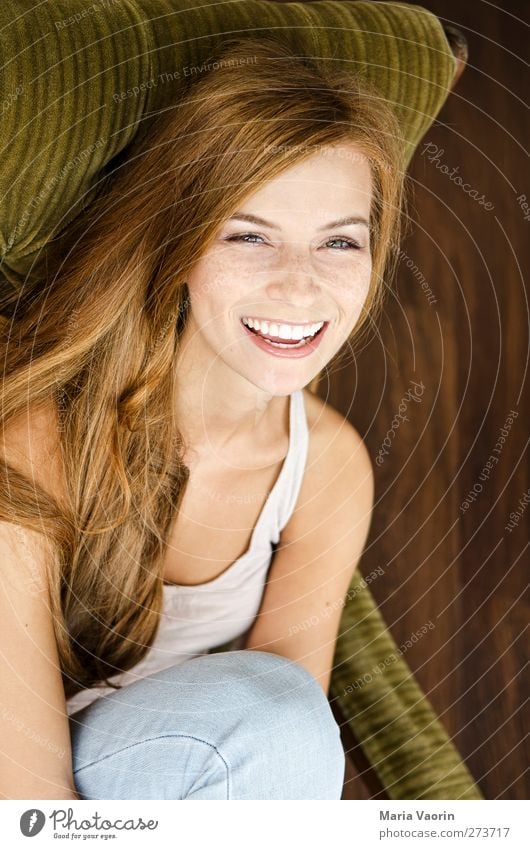 Gute-Laune-Bild Häusliches Leben Sessel Wohnzimmer Mensch feminin Junge Frau Jugendliche 1 18-30 Jahre Erwachsene Jeanshose brünett langhaarig Erholung Lächeln