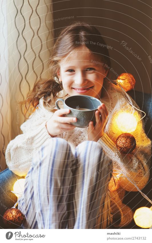 Kind Mädchen trinkt heißen Kakao zu Hause im Winter trinken Tee Leben Erholung Dekoration & Verzierung Stuhl Feste & Feiern Weihnachten & Advent Kindheit sitzen