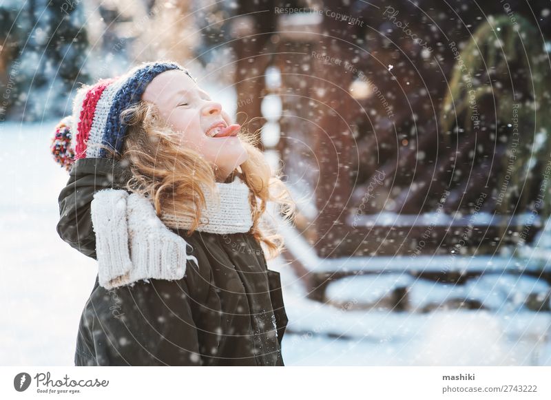 fröhliches Kind Mädchen beim Schneeflockenfangen und Spielen Freude Glück stricken Ferien & Urlaub & Reisen Winter Garten Wetter Wald Schal Hut Tropfen Lächeln
