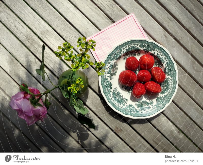 SommerFreuden Frucht Erdbeeren Teller Glück Häusliches Leben Tisch Rose Weinraute Vase frisch hell lecker Wärme grau rot Lebensfreude Holztisch Serviette
