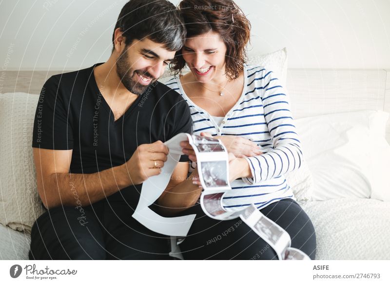 Glückliches schwangeres Paar beim Betrachten der Ultraschallbilder schön Leben Baby Frau Erwachsene Mann Eltern Mutter Vater Familie & Verwandtschaft Lächeln
