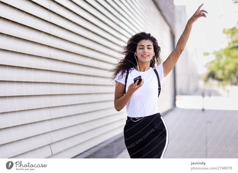 Afrikanische Frau beim Musikhören mit Kopfhörern und Smartphone Stil Freude Glück schön Haare & Frisuren Sport Telefon PDA Technik & Technologie Mensch feminin