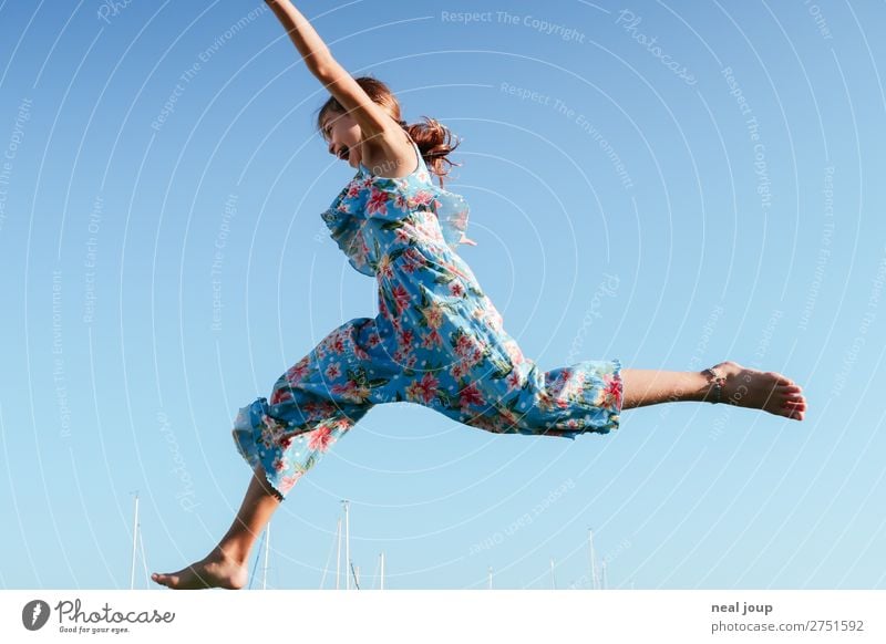 Junges Mädchen in Jumpsuit mit Blumenmuster springt vor blauem Himmel nach links sportlich Spielen feminin 1 Mensch 8-13 Jahre Kind Kindheit Wolkenloser Himmel
