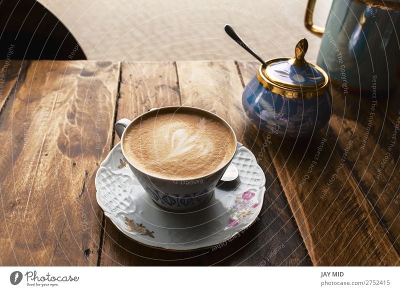Cappuccino-Kaffee in klassischer Porzellantasse auf dem Holztisch Frühstück Getränk Espresso kaufen Tisch Restaurant Blume frisch heiß braun Farbe Tasse