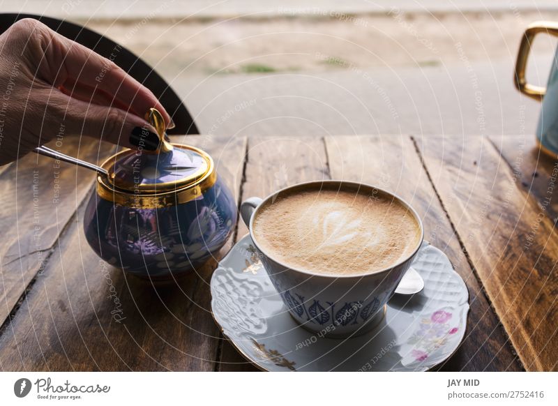 Cappuccino-Kaffee in klassischer Porzellantasse auf dem Holztisch Lebensmittel Frühstück Getränk Milch Latte Macchiato Espresso Tasse Becher Löffel Lifestyle