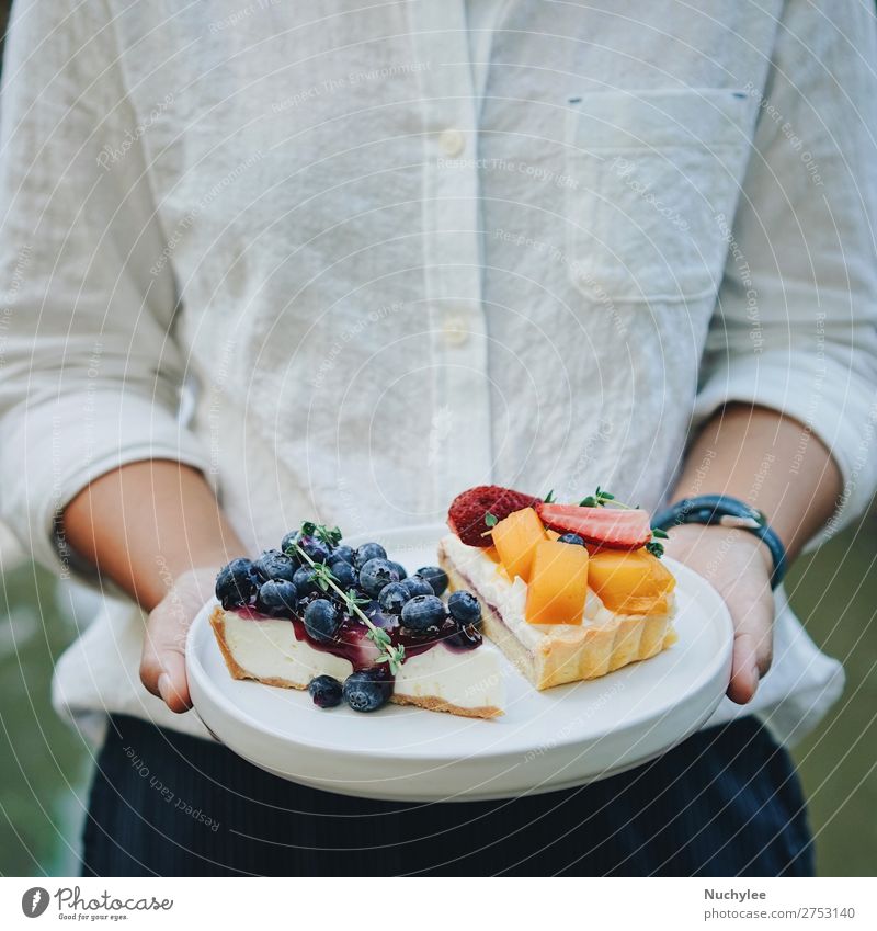 Nahaufnahme Frau Hände halten Teller von Kuchen Käse Frucht Dessert Sommer Restaurant Erwachsene Hand frisch lecker weiß Hintergrund Bäckerei Blaubeeren Café