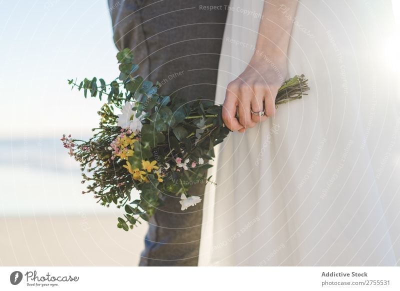 Pflanzenbraut mit Blumenstrauß, der den Bräutigam umfasst. Paar hochzeitlich Umarmen Feste & Feiern Hochzeit Natur romantisch Strand reisend Liebe rustikal