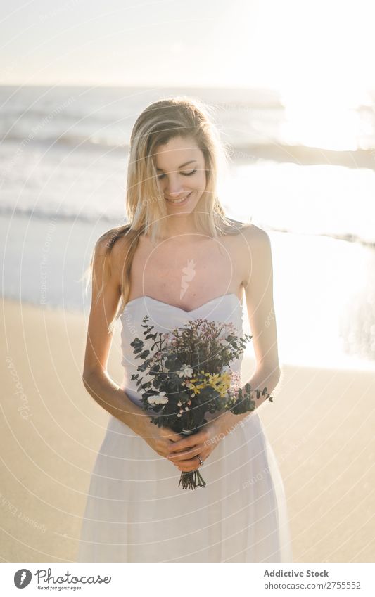 Charmante junge Braut mit Blumen am Strand Frau Blumenstrauß Fröhlichkeit Porträt heiter Menschliches Gesicht Kleid verliebt Liebe elegant Engagement Ausdruck