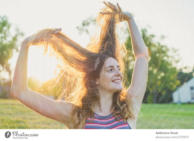 Mädchen, das im Sonnenlicht posiert und mit Haaren spielt. Frau spielerisch Park Behaarung Körperhaltung Freiheit Sommer Spielen Jugendliche Freude Natur