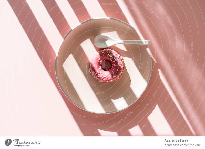 Süßer Doughnut in Sonnenstreifenform Krapfen minimalistisch rosa Sonnenlicht Streifen geometrisch Backwaren Teller Konfekt süß Hundefutter frisch Streusel