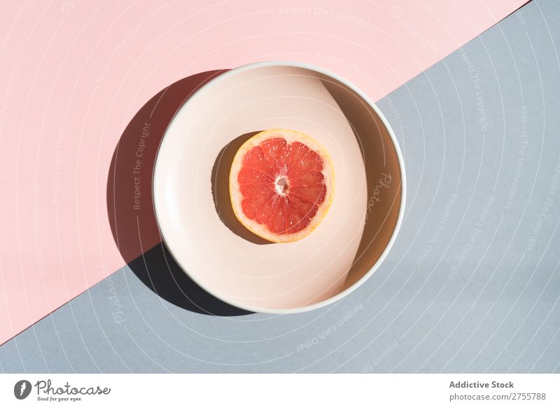 Grapefruit halb auf rundem Teller Ordnung Farbe Studioaufnahme Symmetrie geometrisch Scheibe exotisch süß Zusammensetzung Gesundheit minimalistisch frisch