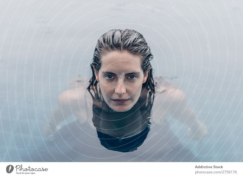 Frau, die auf die Kamera im Wasser schaut. lügen Schwimmsport Gesicht Blick in die Kamera auf den Kopf gestellt Schwimmbad Mensch Sommer blau