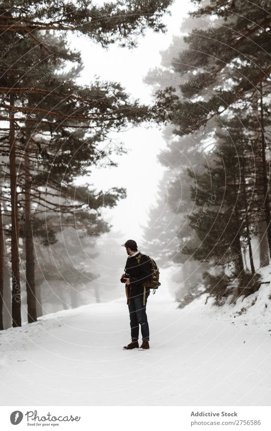 Touristen stehen im verschneiten Wald Mann Backpacker Straße Winter Natur Schnee kalt Frost Jahreszeiten Landschaft weiß schön ländlich Blick nach hinten
