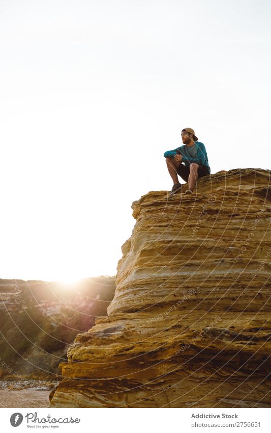 Mann sitzt auf einer Klippe. Tourist Felsen Ferien & Urlaub & Reisen Tourismus Natur Landschaft sitzen ruhen Sonne Freiheit Stein natürlich Lifestyle schön